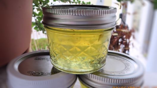 three jars filled with yellow liquid sitting on top of a table