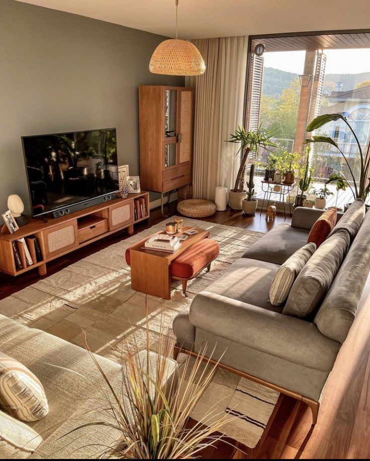 a living room filled with furniture and a flat screen tv on top of a wooden stand