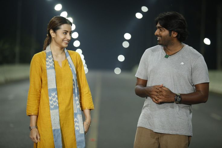 a man and woman standing next to each other in front of street lights at night