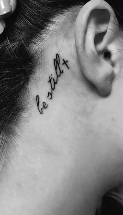 a woman's behind the ear tattoo reads, let it be