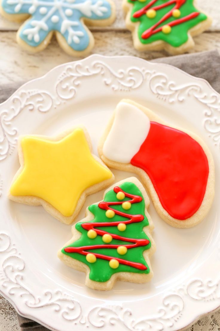 three decorated christmas cookies on a white plate