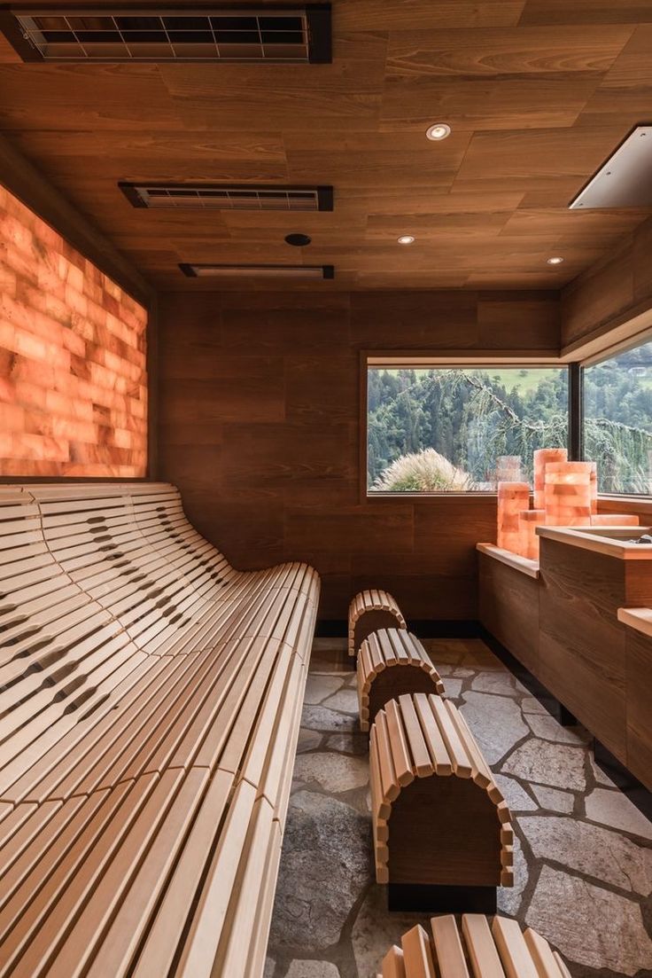 a wooden bench sitting next to a window on top of a stone floored floor