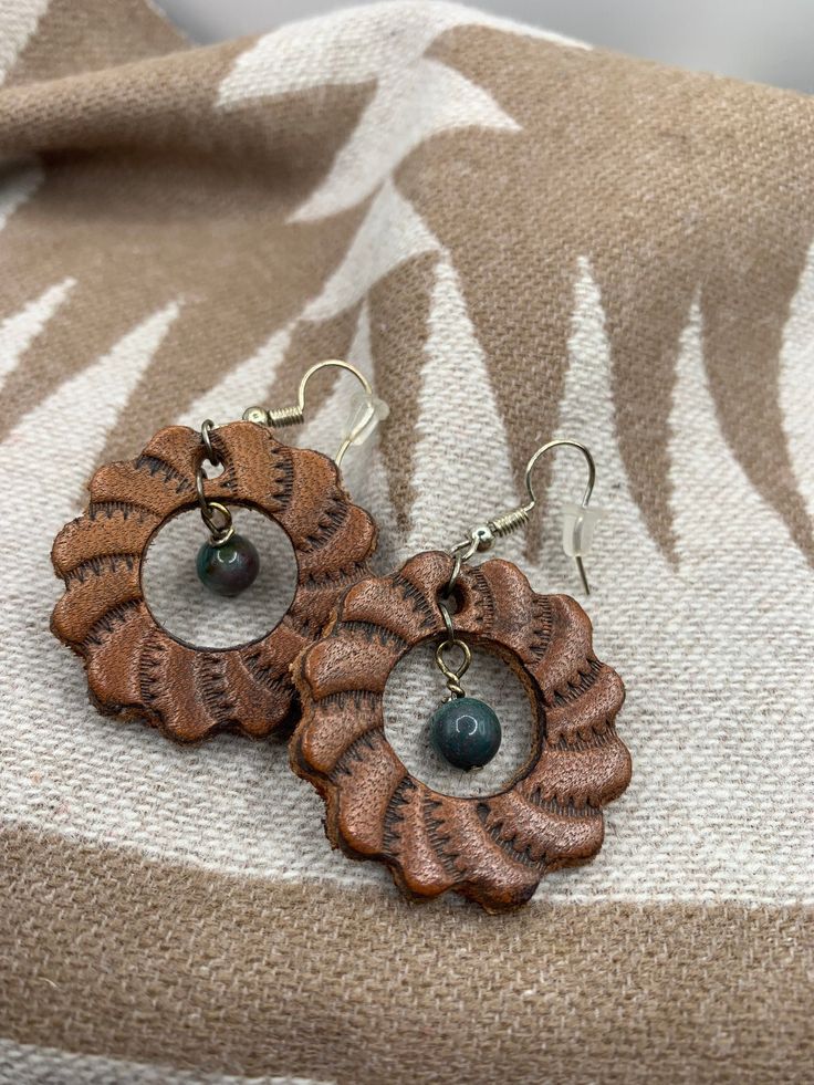 Leather Concho earrings. Made in Wyoming. Quality leather and stone used. Hypoallergenic earring wires. Artisan Leather Nickel-free Earrings, Elegant Hand-tooled Brown Jewelry, Elegant Hand Tooled Brown Jewelry, Everyday Hand-tooled Leather Jewelry, Everyday Hand Tooled Leather Jewelry, Hand Tooled Bohemian Jewelry For Everyday, Bohemian Hand Tooled Jewelry For Everyday Use, Unique Brown Round Earrings, Earthy Brown Earrings With Ear Wire