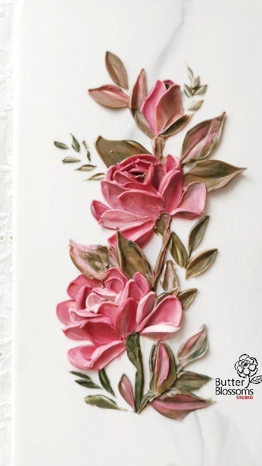 some pink flowers and leaves on a white surface