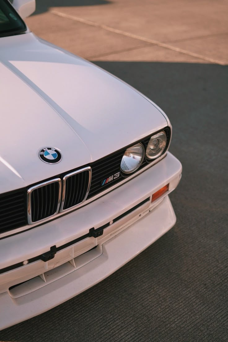 the front end of a white bmw car