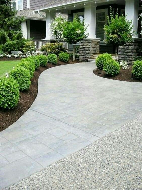 a driveway with landscaping in front of a house