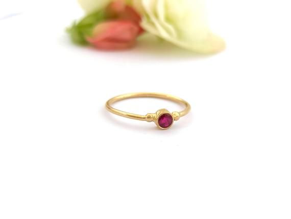 Minimalist solitaire 14k yellow, white, or rose gold ring with a beautiful round natural Ruby, dainty stacked solid gold ring. This dainty 14K yellow gold ring has a tiny round Ruby in the center, with two little gold dots at each side. This ring is delicate and comfortable to wear and will be great for everyday use, as for a special occasion. You can wear it on its own as a minimalist ring or stacked with other rings of deferent color or texture. This ring can also be a great modern engagement Dainty Round Ruby Ring With Bezel Setting, Minimalist Solitaire Ruby Ring With Round Band, Minimalist Ruby Promise Ring, Minimalist Round Ruby Promise Ring, Minimalist Ruby Promise Ring With Round Band, Yellow Gold Solitaire Ruby Ring Gift, Minimalist Ruby Birthstone Ring, Minimalist Ruby Ring Birthstone, Dainty Round Cut Ruby Ring