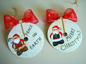 two christmas ornaments with santa clause and red bow hanging from the front of each ornament