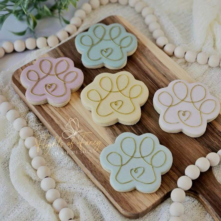 four decorated cookies sitting on top of a wooden board