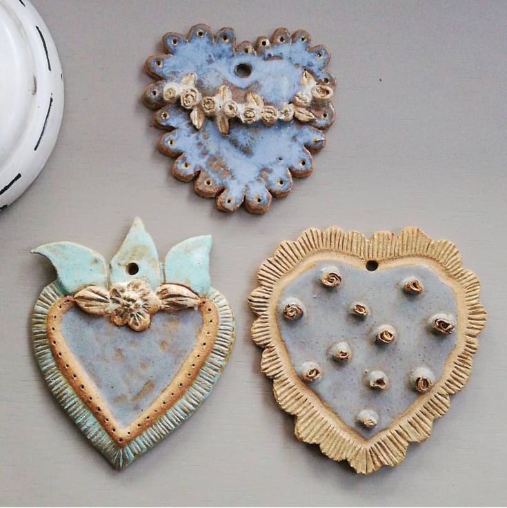 three decorative heart shaped ornaments on a table