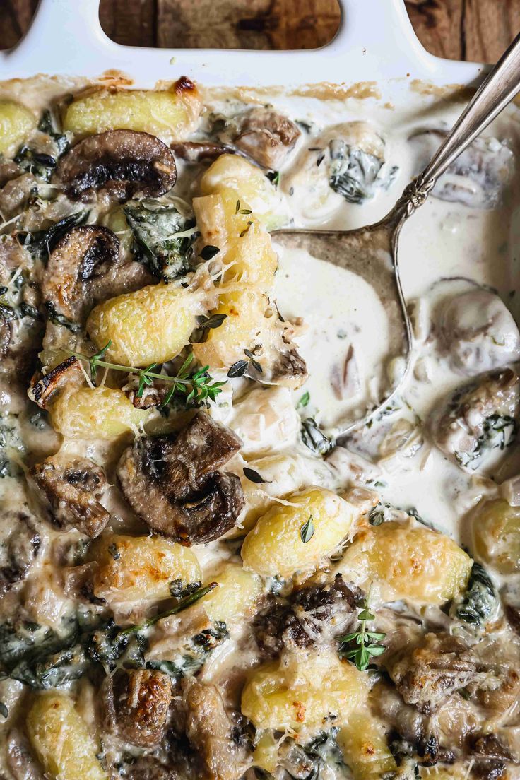 a casserole dish with mushrooms, cheese and herbs on it is ready to be eaten