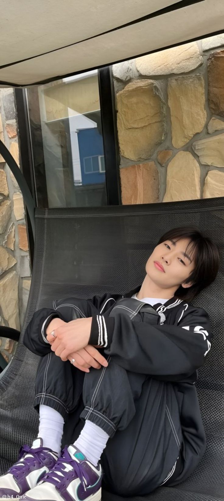 a young boy sitting on top of a black chair