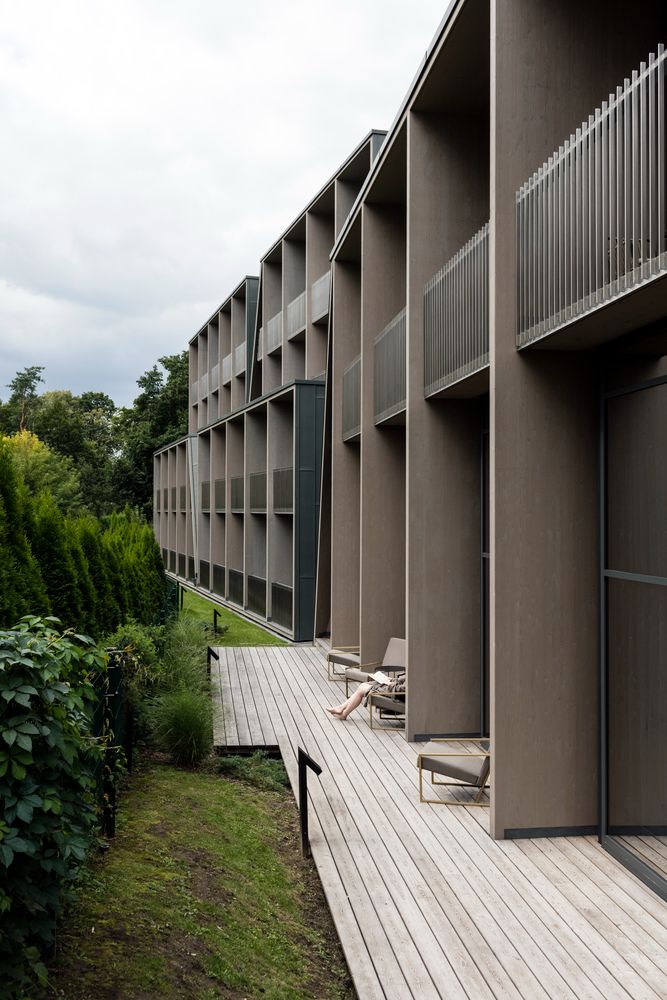 an apartment building with several balconies and lawn chairs on the decking area