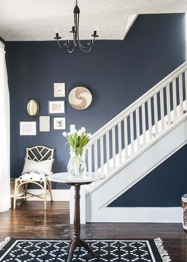 a living room with blue walls and white stairs