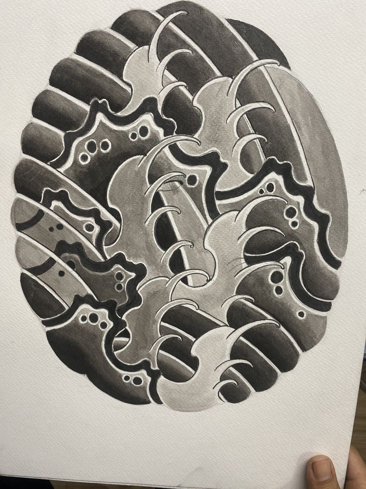 a drawing of an abstract design in grey and black ink on white paper with a hand holding