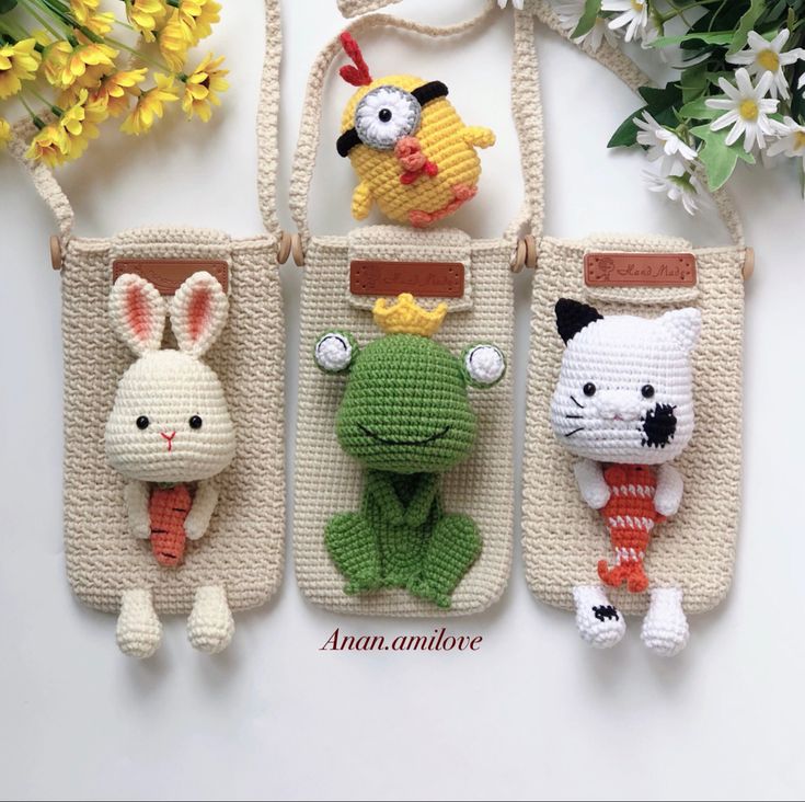 three crocheted purses with stuffed animals in them and one is holding an animal