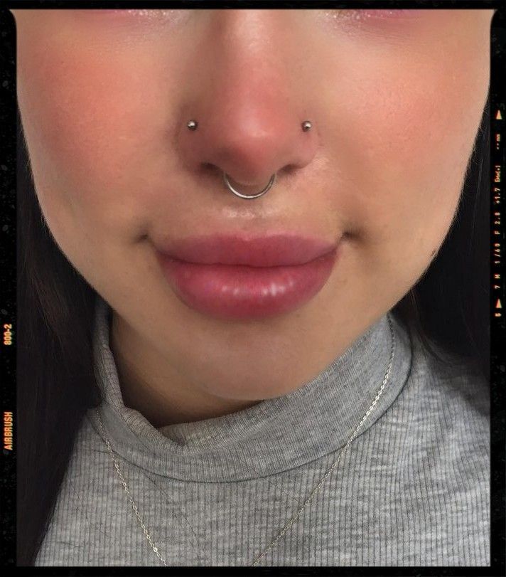 a close up of a woman with a nose piercing