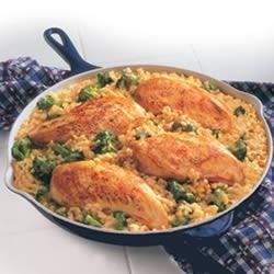 chicken and rice in a skillet on a white table with blue checkered napkins