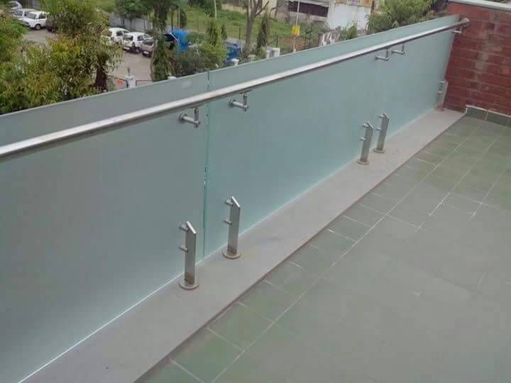 an outdoor balcony with glass railings and handrails on the side of it