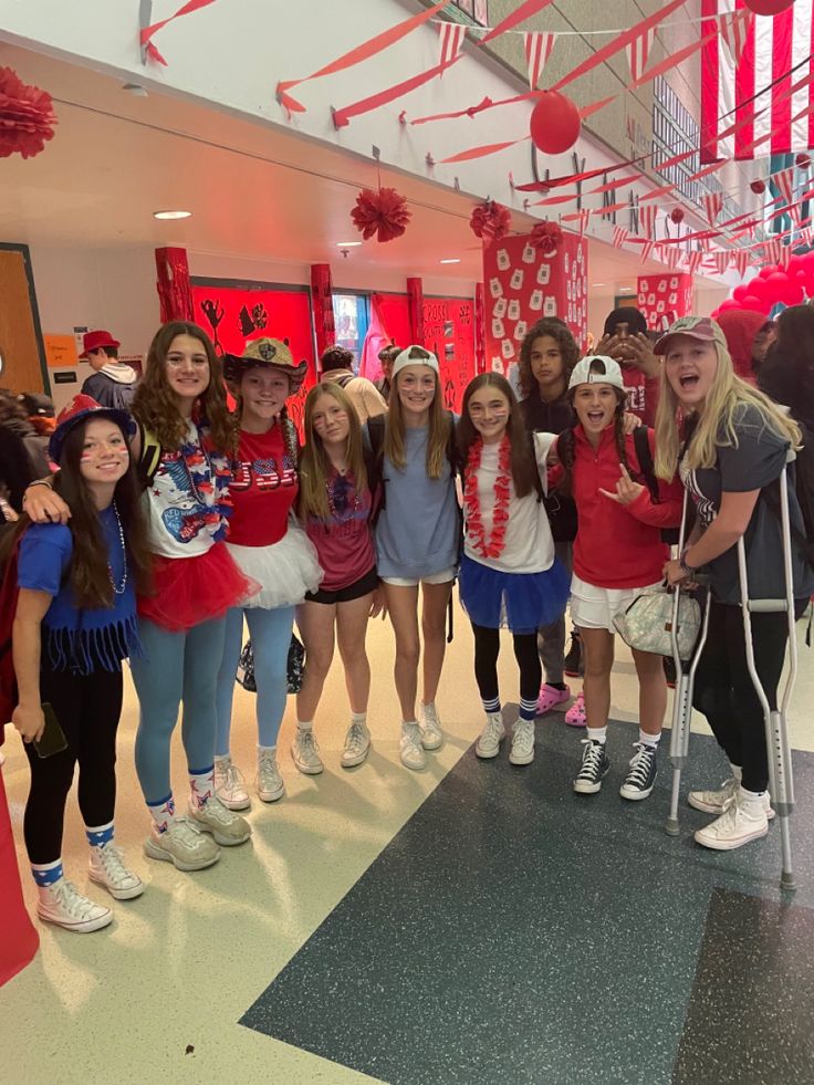 a group of girls standing next to each other in front of a red and white wall