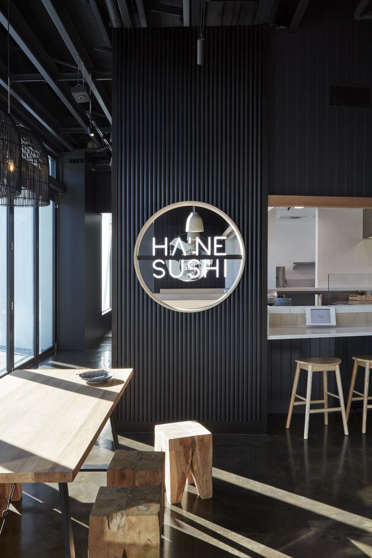 the interior of a sushi restaurant with wooden tables and stools