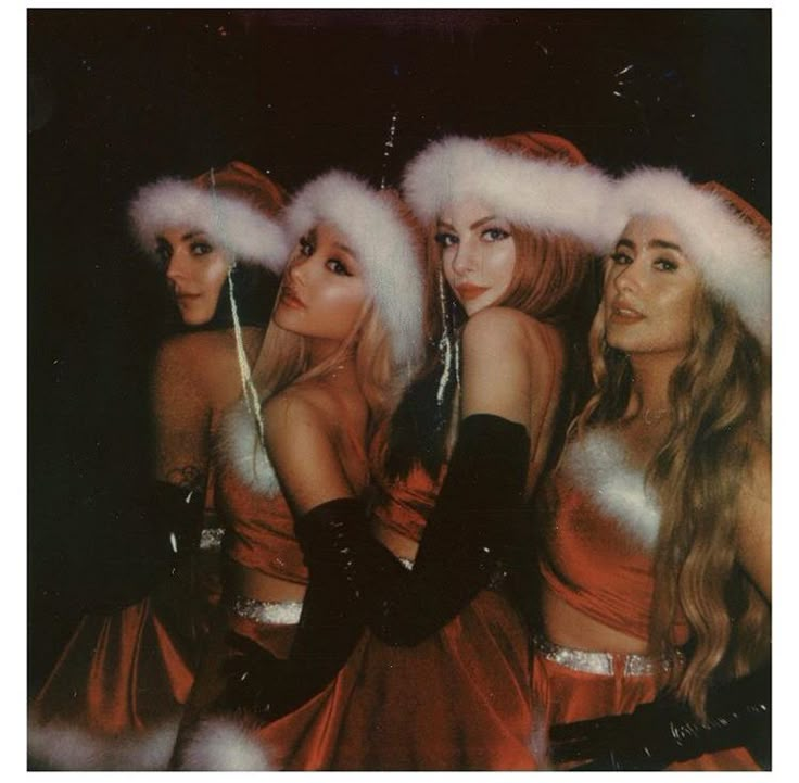 the girls are dressed up in santa hats