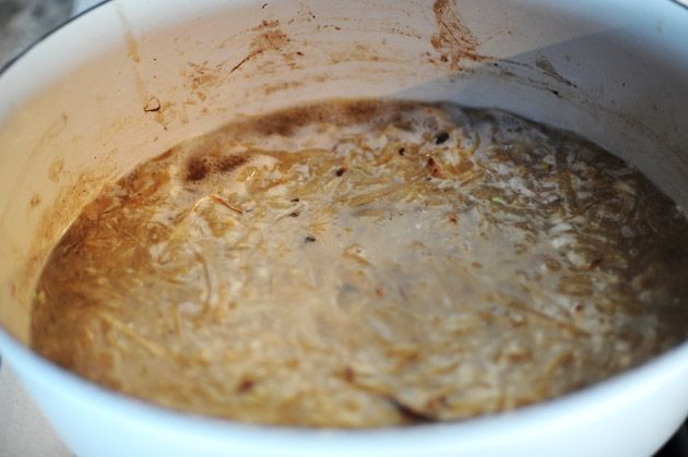 a pot filled with brown liquid on top of a stove