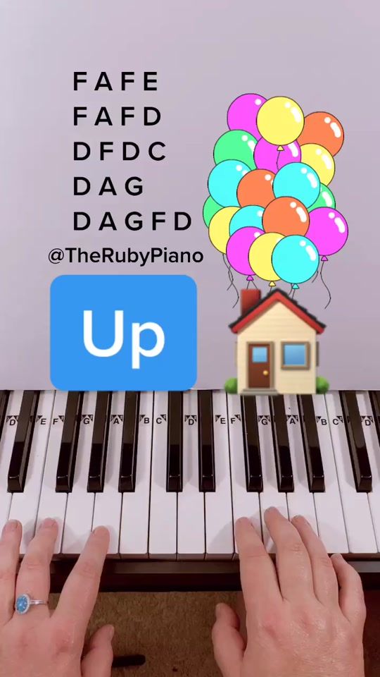 two hands are playing the piano with balloons on top of it and an up sign above them