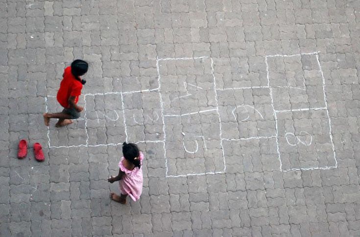 two children are playing with chalk drawings on the ground