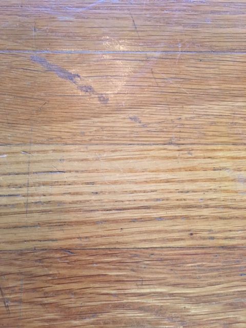 a close up view of a wooden surface with stains and scratches on the wood grain