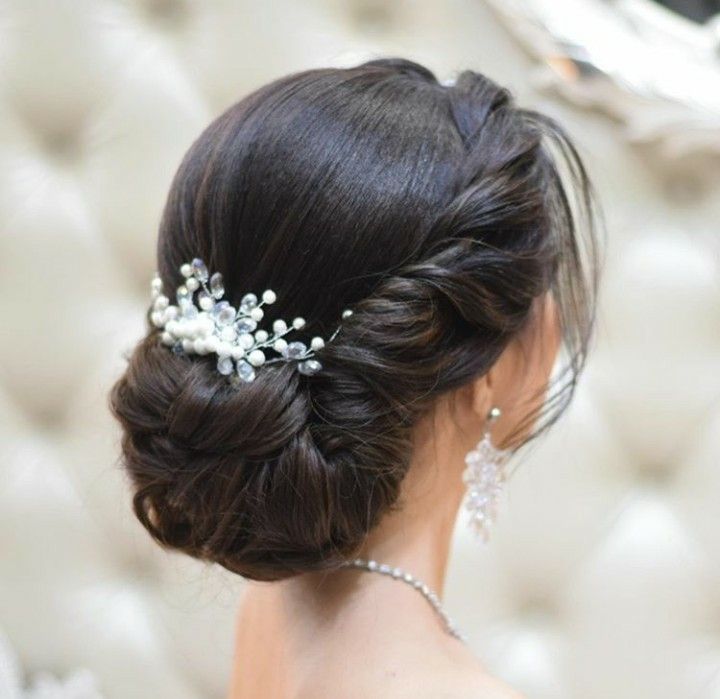 a woman wearing a bridal hair comb with pearls on it's back and side