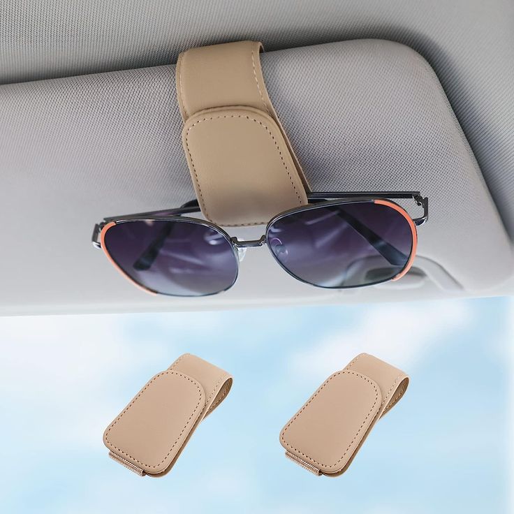 two pairs of sunglasses sitting in the back seat of a car next to a pair of glasses