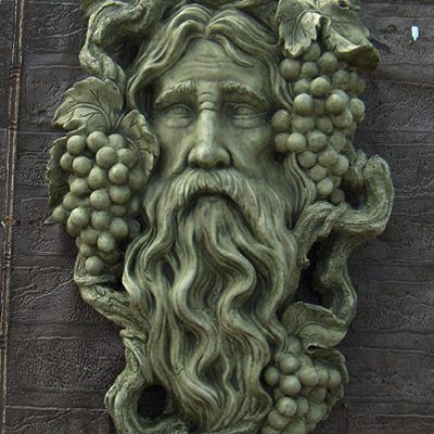 a statue of a bearded man with grapes on his head