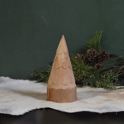 a wooden cone sitting on top of a table next to pine cones and greenery