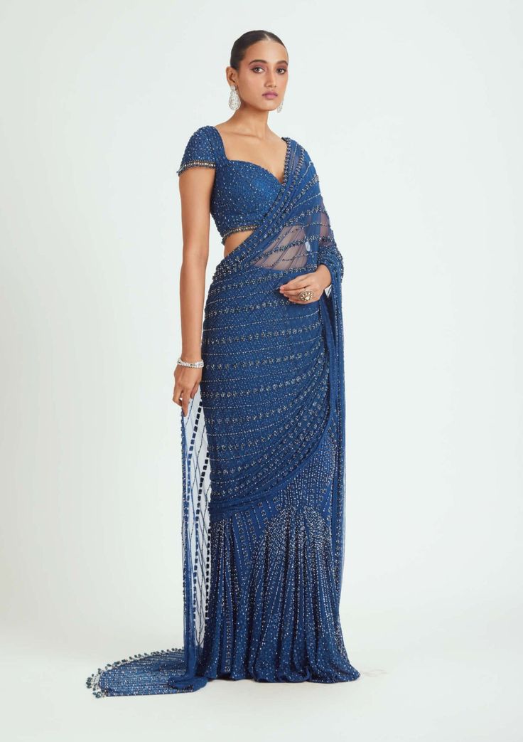 Elevate your style with our cobalt blue net pre-draped sari, adorned with tonal beadwork, sequins, and crystals. This sari is a captivating choice for special events and celebrations, offering a glamorous and elegant look without the hassle of draping. Make a bold fashion statement in this stunning ensemble. Traditional Blue Pre-draped Saree For Party, Festive Blue Pre-draped Saree For Evening, Festive Blue Wedding Pre-draped Saree, Blue Zari Work Party Wear Pre-draped Saree, Blue Pre-draped Saree With Dupatta For Reception, Bollywood Style Blue Pre-draped Saree, Evening Blue Georgette Saree, Blue Bollywood Pre-draped Saree For Evening, Elegant Blue Pre-draped Saree For Festive Occasions