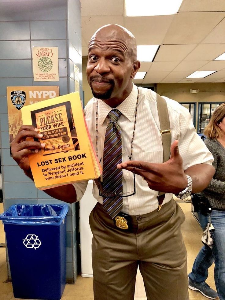 a man in suspenders and a tie holding up a book