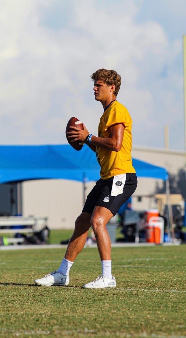 a man holding a football on top of a field