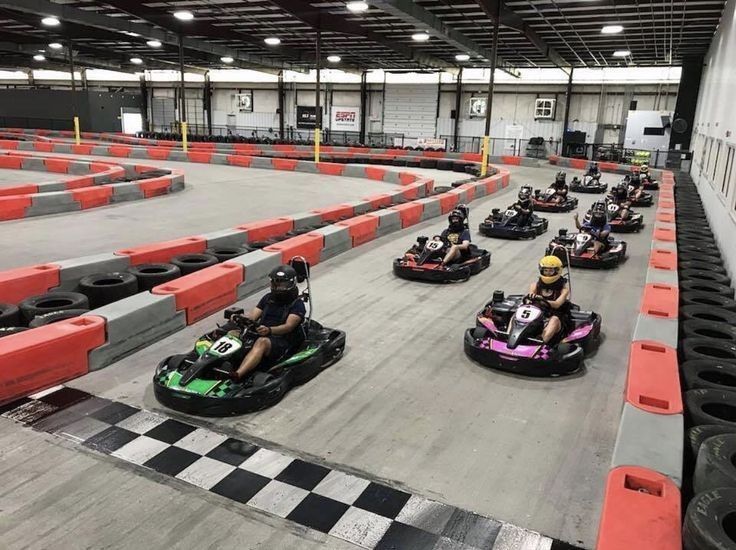 several people riding bumper cars in an indoor race track