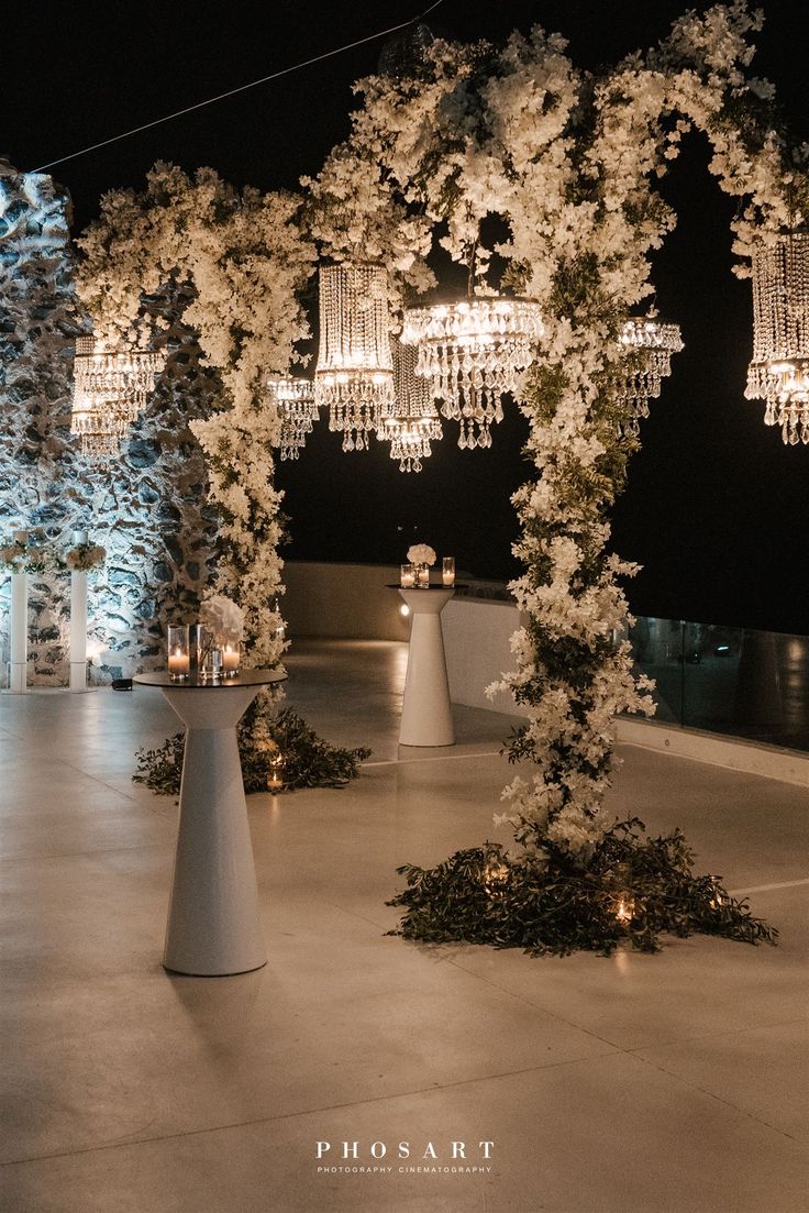 an outdoor wedding setup with chandeliers and flowers