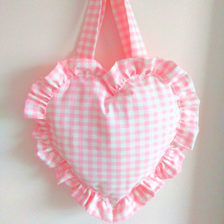 a pink and white heart shaped bag hanging on a wall