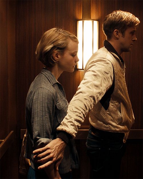 a man and woman standing next to each other in front of a window with bars on them