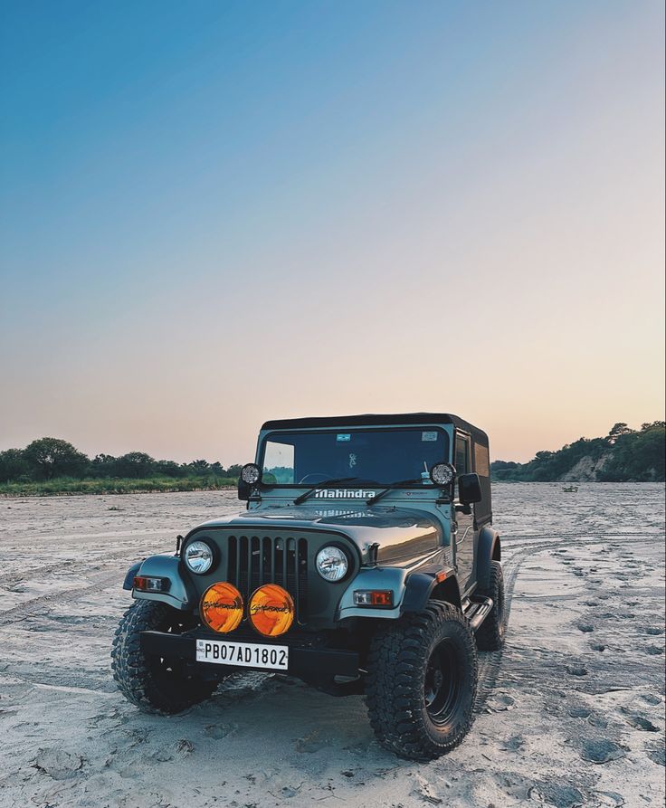 the jeep is parked in the sand on the beach