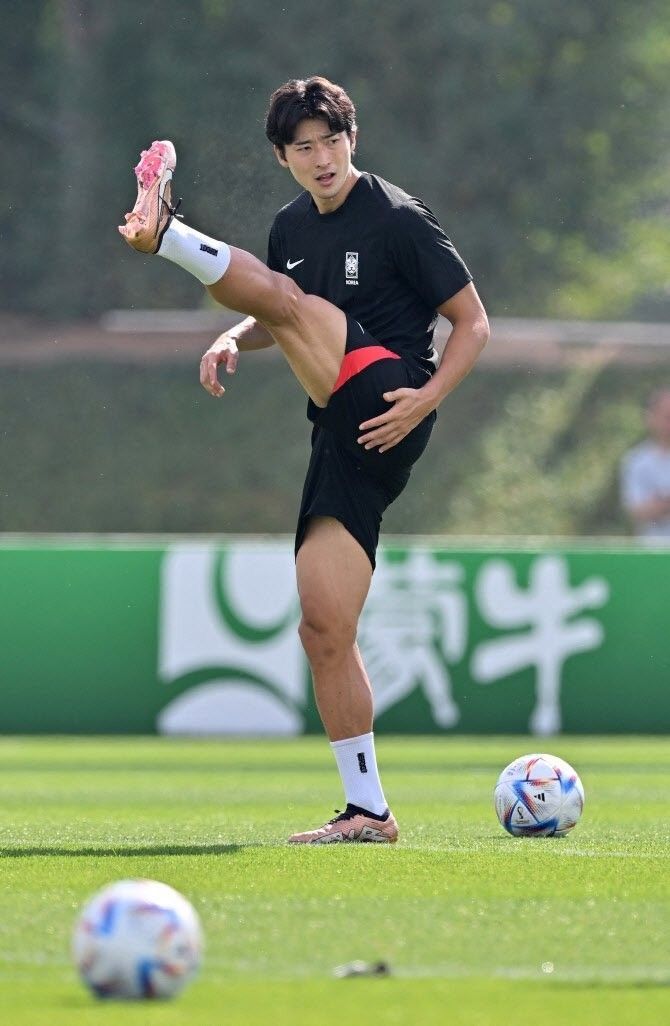 a man kicking a soccer ball on top of a field