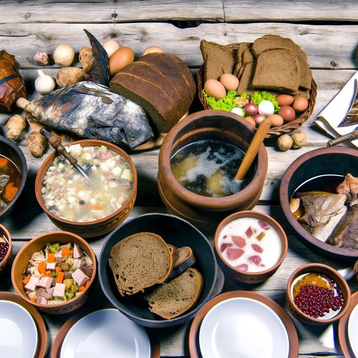 an assortment of food is laid out on a table with bread, soup and other foods