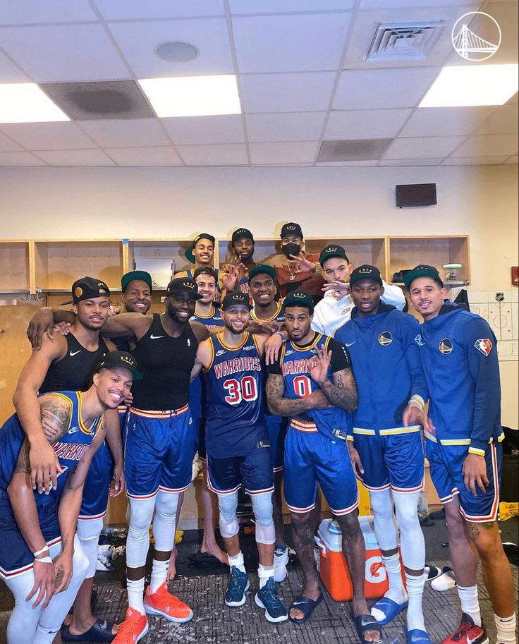 a group of men standing next to each other in front of a locker room wall