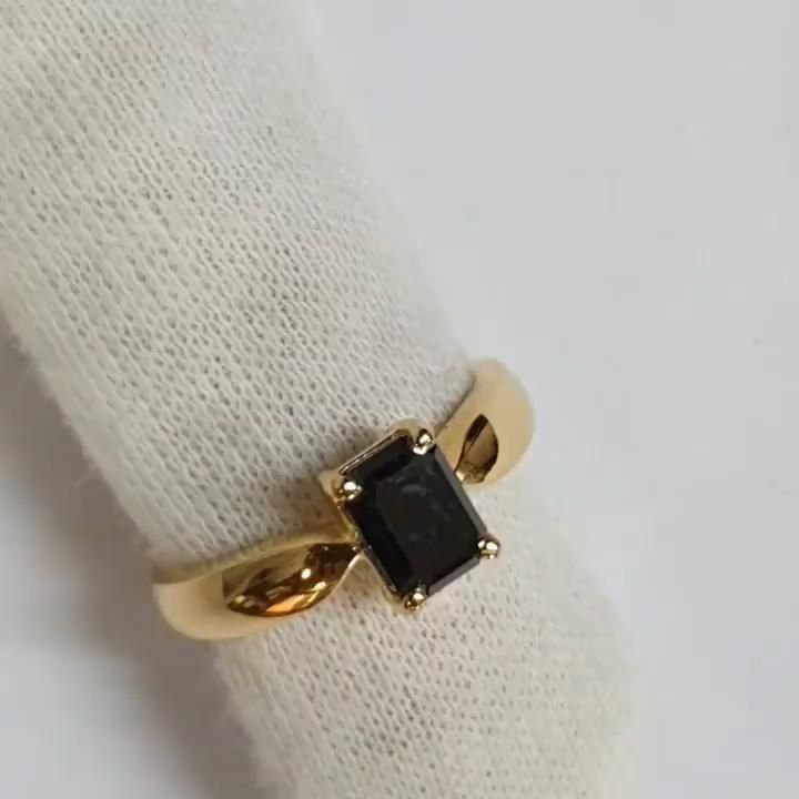 a gold ring with a black stone on it