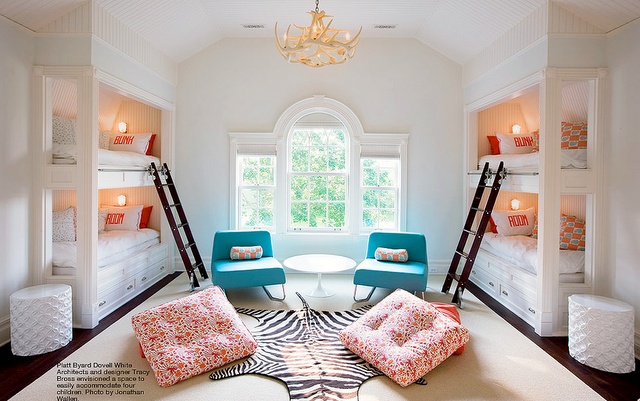 a room with bunk beds, chairs and a zebra rug on the floor in front of a window