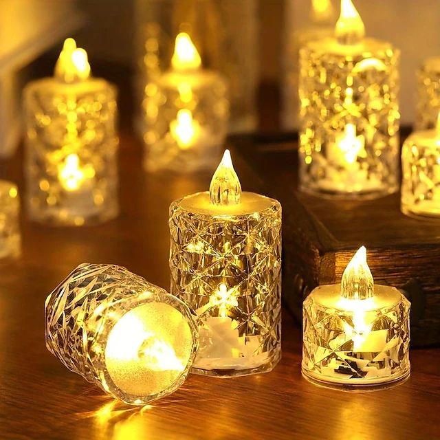 several lit candles sitting on top of a wooden table next to a mirror container filled with lights