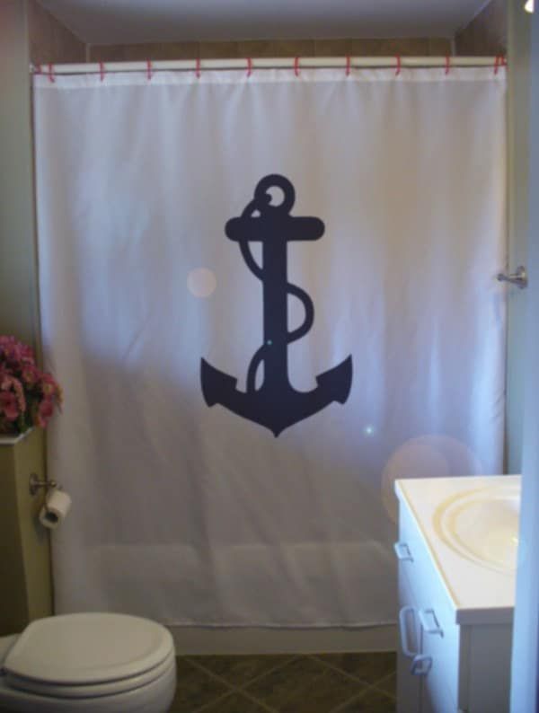 a bathroom with a shower curtain that has an anchor on it