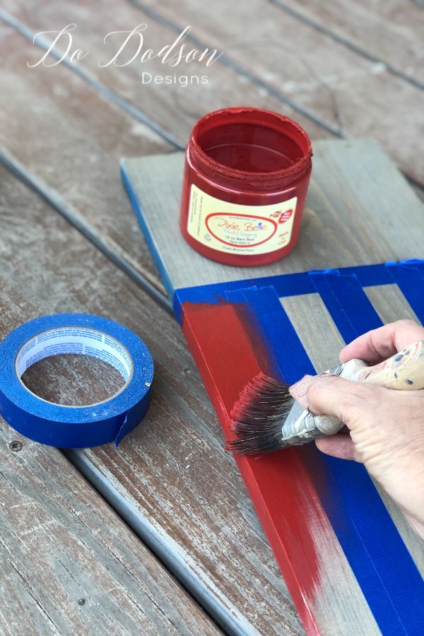 a person is using a brush to paint a piece of wood